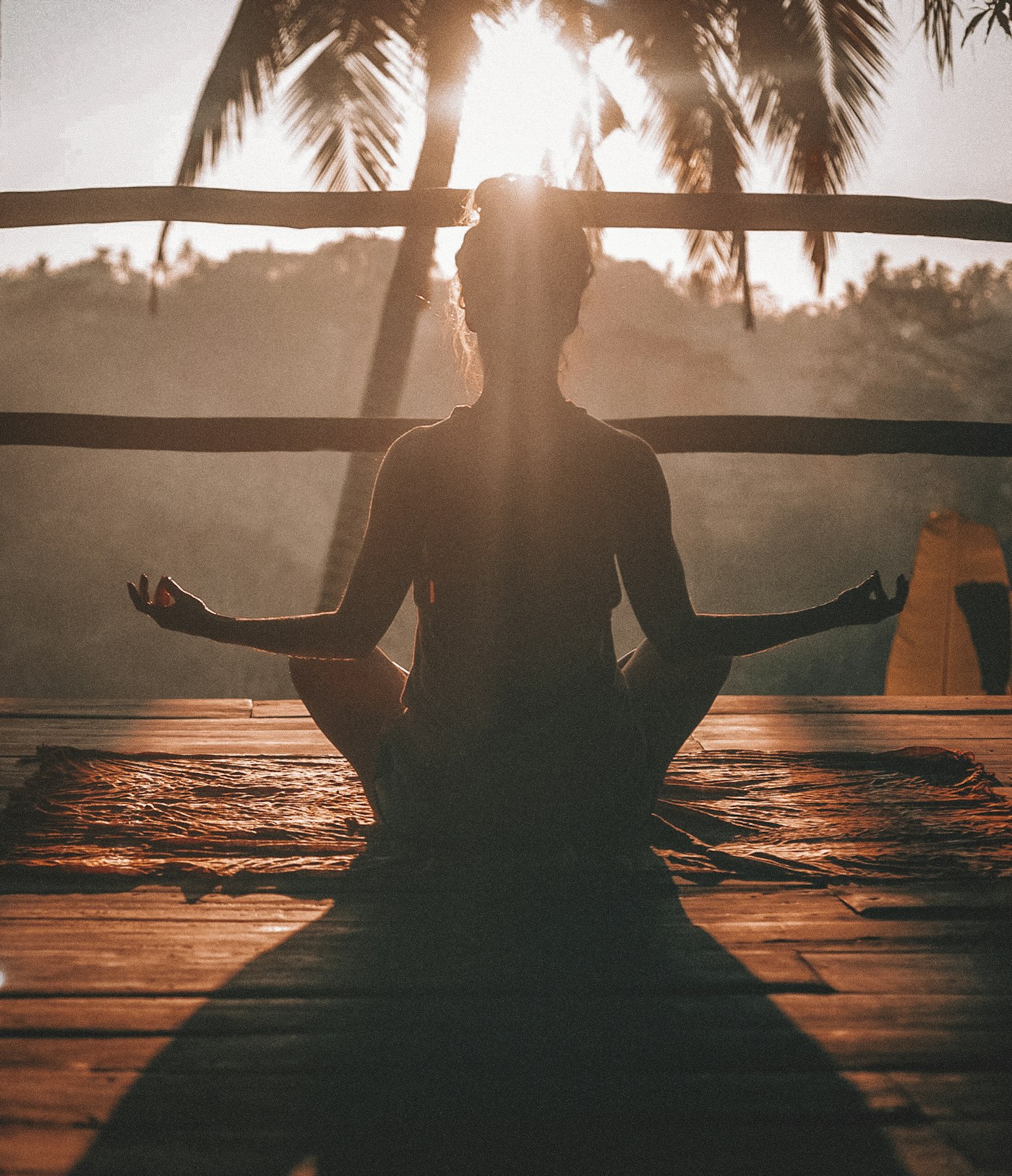 Woman meditating at sunrise